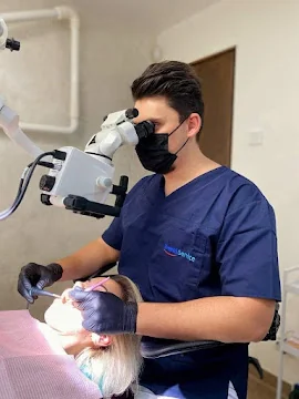 Medic Denti Service Bacău realizând un tratament endodontic sub microscop dentar, cu magnificare și iluminare focusată